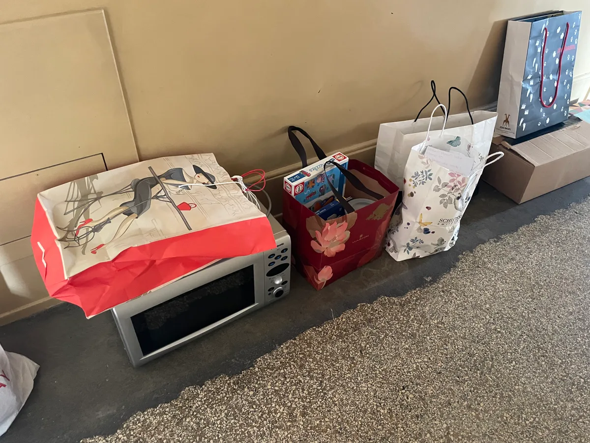 In einem Flur stehen Säcke mit Alltagsgegenständen.